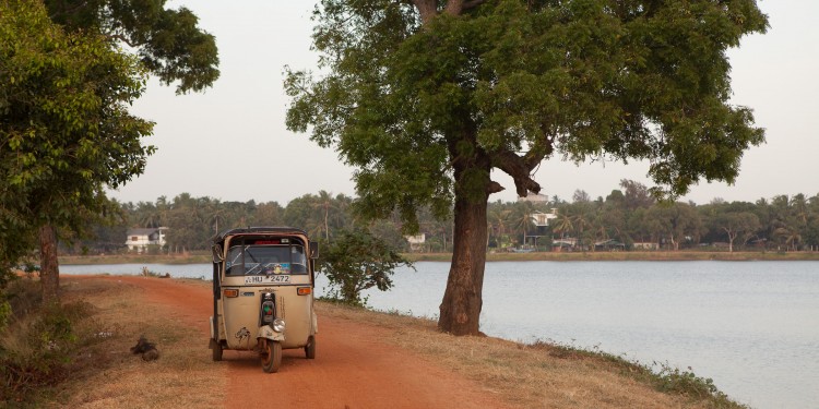 Tuk Tuk parked on the wall of the Kumbichchan Kulama 'Tank'. These enormous reservoirs began to be built in the 3rd century BC using sophisticated techniques not acquired by western engineers until the 18th century.